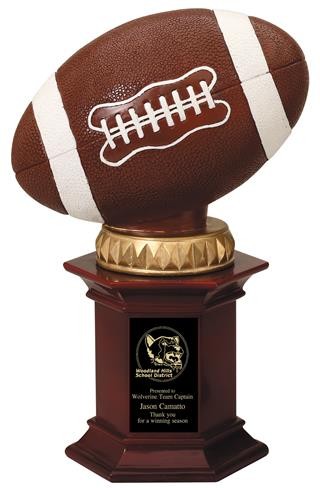 Football resting on a rosewood stained resin pedestal. 1